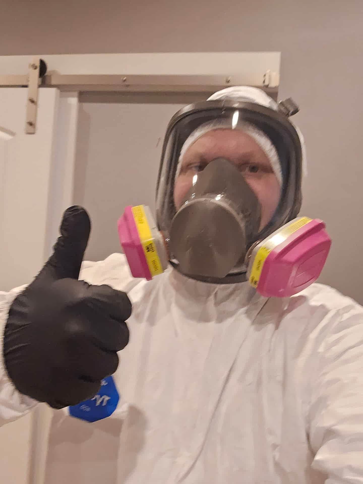Adriatic Water Restoration technician wearing a full-face respirator and protective equipment.